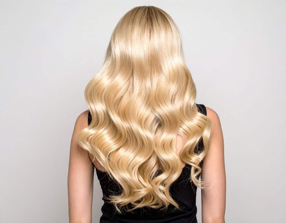 Natural light blonde hair with soft waves and full, glossy volume